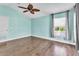 Spacious bedroom features a ceiling fan, wood floors, and a window providing plenty of natural light at 2310 Wood Pointe Dr, Holiday, FL 34691
