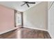 Bedroom with wood floor, ceiling fan, and soft pink accent wall at 2310 Wood Pointe Dr, Holiday, FL 34691