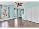 Bright bedroom boasts hardwood floors, two windows, and a closet providing ample storage space at 2310 Wood Pointe Dr, Holiday, FL 34691