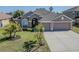 Inviting single-Gathering home showcasing lush landscaping and a spacious driveway at 2310 Wood Pointe Dr, Holiday, FL 34691
