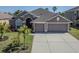 Charming single-story home with a well-manicured lawn and a spacious three-car garage at 2310 Wood Pointe Dr, Holiday, FL 34691