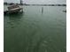 Scenic waterfront view featuring a partially collapsed wooden dock extending into calm, green water at 249 144Th Ave, Madeira Beach, FL 33708