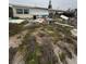Single-story home surrounded by debris and overgrown vegetation at 249 144Th Ave, Madeira Beach, FL 33708