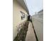 Narrow side yard featuring a weathered walkway, overgrown shrubs, and a white fence at 249 144Th Ave, Madeira Beach, FL 33708