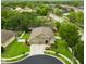 Aerial view of a two-story home with a well-manicured lawn, mature landscaping, and three-car garage at 30623 Bittsbury Ct, Wesley Chapel, FL 33543