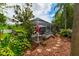 Backyard view showing a well-maintained, screened-in pool and lush tropical landscaping at 30623 Bittsbury Ct, Wesley Chapel, FL 33543