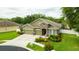 Inviting two-story home featuring a manicured lawn, mature landscaping, and a three-car garage at 30623 Bittsbury Ct, Wesley Chapel, FL 33543