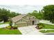 Inviting two-story home featuring a manicured lawn, mature landscaping, and a three-car garage at 30623 Bittsbury Ct, Wesley Chapel, FL 33543