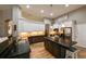 Gourmet kitchen featuring white cabinets, dark counters, stainless steel appliances, and center island, perfect for cooking at 30623 Bittsbury Ct, Wesley Chapel, FL 33543