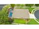 Aerial view of a screened-in pool and spa, surrounded by a manicured lawn and landscaping at 30623 Bittsbury Ct, Wesley Chapel, FL 33543