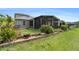Beautiful backyard with lush landscaping, green grass, and a screened-in lanai at 3219 Gianna Way, Land O Lakes, FL 34638