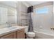 Full bathroom featuring tiled shower-tub, a shelving unit, and a framed mirror at 3219 Gianna Way, Land O Lakes, FL 34638