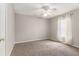 Neutral bedroom with carpet flooring, ceiling fan, white trim, and a bright window at 3219 Gianna Way, Land O Lakes, FL 34638