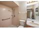 Bathroom featuring tiled walk-in shower, a mirror, and toilet at 34796 Hibiscus St, Dade City, FL 33525