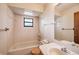 Bathroom with a bathtub, sink, and a large mirror, with a rectangular window providing natural light at 34796 Hibiscus St, Dade City, FL 33525