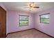 Bedroom showcasing light purple walls and two windows with a view and a ceiling fan at 34796 Hibiscus St, Dade City, FL 33525