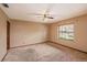Bedroom featuring carpet flooring, ceiling fan, and a window providing natural light at 34796 Hibiscus St, Dade City, FL 33525
