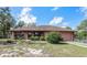 Charming single story house featuring a fenced front yard, mature landscaping, and attached two-car garage at 34796 Hibiscus St, Dade City, FL 33525