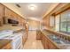 Galley kitchen featuring wooden cabinets, granite countertops, stainless steel microwave, and tile floors at 34796 Hibiscus St, Dade City, FL 33525