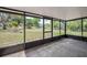 View of the backyard from the screened-in patio, highlighting the lawn and some trees at 34796 Hibiscus St, Dade City, FL 33525