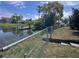 Scenic backyard with a pond view and private dock area, enhanced by lush landscaping and a secure fence at 3542 Delta Pl, Holiday, FL 34691