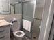 Bright bathroom with tiled walls, open toilet, glass shower doors and convenient mirrored vanity at 3542 Delta Pl, Holiday, FL 34691