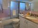 Bathroom featuring a shower with glass doors, pink tile walls, and a vanity with a sink at 3542 Delta Pl, Holiday, FL 34691