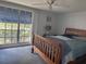 Sunlit bedroom featuring a wooden bed frame, ceiling fan, and large window with serene outdoor views at 3542 Delta Pl, Holiday, FL 34691