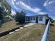Exterior view of the home with concrete steps leading to a screened door and a partially fenced backyard at 3542 Delta Pl, Holiday, FL 34691