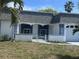 Inviting home exterior with a gray roof, white walls, and palm trees, complemented by a well-maintained front yard at 3542 Delta Pl, Holiday, FL 34691