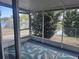 Enclosed lanai with neutral patterned rug, providing serene views of the landscaped backyard at 3542 Delta Pl, Holiday, FL 34691
