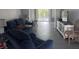 Bright living room with a comfortable blue sofa, tile flooring, and a sliding glass door leading to the outside at 3542 Delta Pl, Holiday, FL 34691