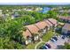 An aerial shot displays the beautiful condo community, surrounded by mature trees and a serene lake at 4002 Crockers Lake Blvd # 1-128, Sarasota, FL 34238