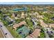 Scenic aerial view of the community featuring a golf course, lake, tennis courts, and lush landscaping at 4002 Crockers Lake Blvd # 1-128, Sarasota, FL 34238