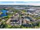Scenic aerial view of a condo community with a pool, lush landscaping, and commercial areas nearby at 4002 Crockers Lake Blvd # 1-128, Sarasota, FL 34238