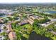 Scenic aerial view of a condo community with lush landscaping, pool, and adjacent golf course and pond at 4002 Crockers Lake Blvd # 1-128, Sarasota, FL 34238