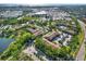 An aerial showcases the beautiful condo community, surrounded by mature trees, and local conveniences at 4002 Crockers Lake Blvd # 1-128, Sarasota, FL 34238