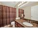 Bathroom with granite countertop, single sink, large mirror, and shower with patterned curtain at 4002 Crockers Lake Blvd # 1-128, Sarasota, FL 34238