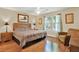 Bedroom with hardwood floors, queen bed with wooden headboard, and a large window at 4002 Crockers Lake Blvd # 1-128, Sarasota, FL 34238