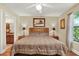 Bedroom with hardwood floors, queen bed with wooden headboard, and ensuite bathroom at 4002 Crockers Lake Blvd # 1-128, Sarasota, FL 34238