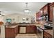 Modern kitchen featuring granite countertops, stainless steel appliances, and cherry cabinets at 4002 Crockers Lake Blvd # 1-128, Sarasota, FL 34238