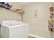 Laundry room with side-by-side washer and dryer, plus shelving for supplies at 4002 Crockers Lake Blvd # 1-128, Sarasota, FL 34238