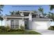 Inviting exterior of home featuring a two-car garage, modern design, and beautiful landscaping at 406 Sun Chaser Dr, Nokomis, FL 34275