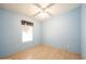 A light-blue bedroom featuring a window, plug-ins, and neutral-toned wood floors at 472 Trout Ln, Oldsmar, FL 34677