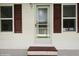 Exterior view of the front door with brown trim and symmetrical shuttered windows at 472 Trout Ln, Oldsmar, FL 34677