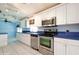 Bright kitchen featuring white cabinetry, stainless steel appliances, and tiled flooring at 472 Trout Ln, Oldsmar, FL 34677
