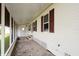 Covered porch with red shutters and a side door to a screened area at 472 Trout Ln, Oldsmar, FL 34677