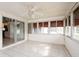 Spacious sunroom with tile flooring, ceiling fan, and access to the kitchen at 472 Trout Ln, Oldsmar, FL 34677