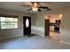 Open-concept living area with a ceiling fan, tile flooring, and a view of the kitchen at 4824 16Th St, Zephyrhills, FL 33542