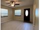 Bright living room with tile floors, modern ceiling fan, and natural light from two windows at 4824 16Th St, Zephyrhills, FL 33542